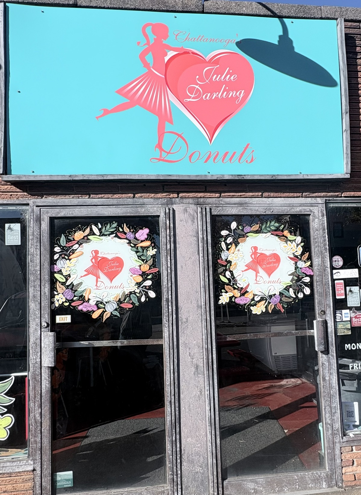 Donut shop storefront with hand-painted fall wreaths on the entry doors